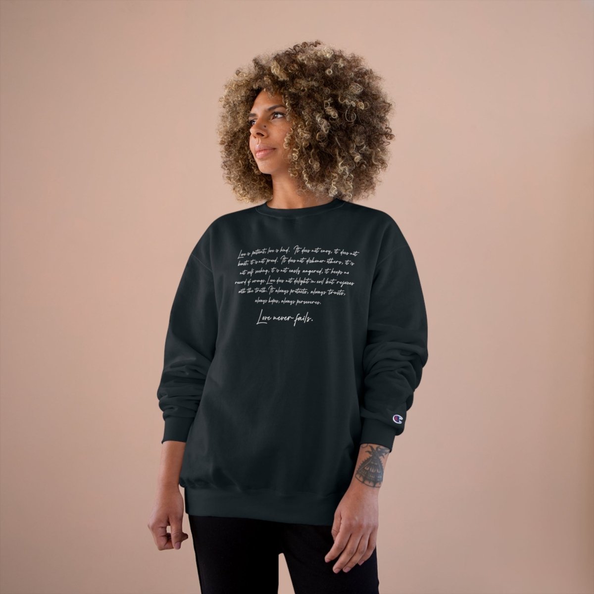 Black Champion unisex sweatshirt by Inkblot featuring "Love Never Fails" slogan, casual fit, suitable for AU, NZ, and US sizes.