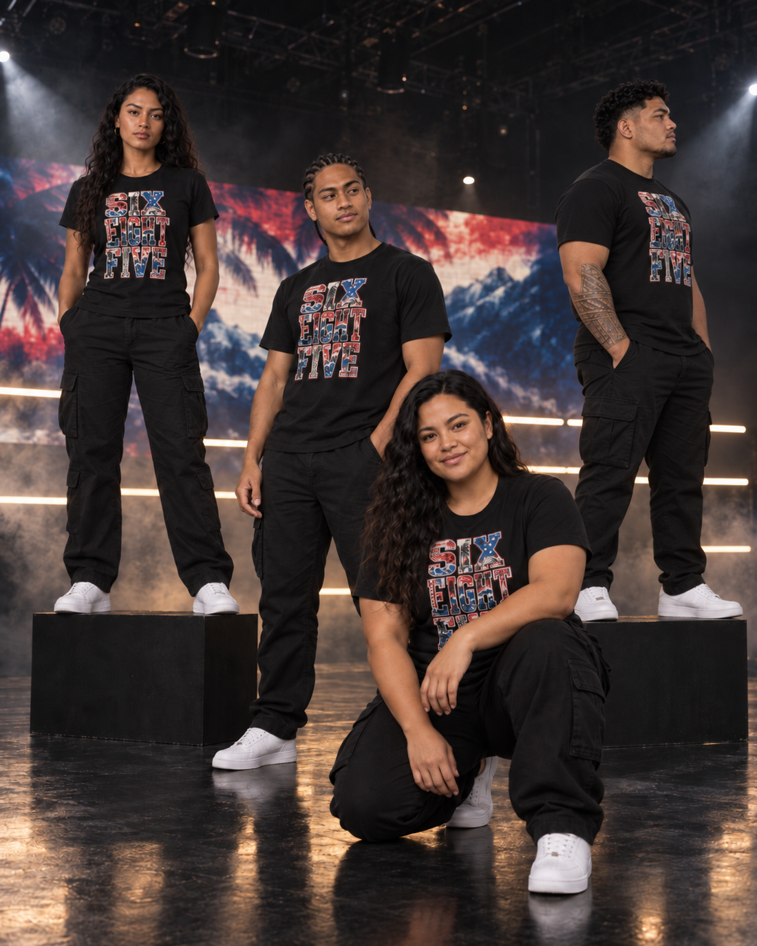 Four friends in the 685 Samoa tee on a dark soundstage, ocean and palms on the screen behind them