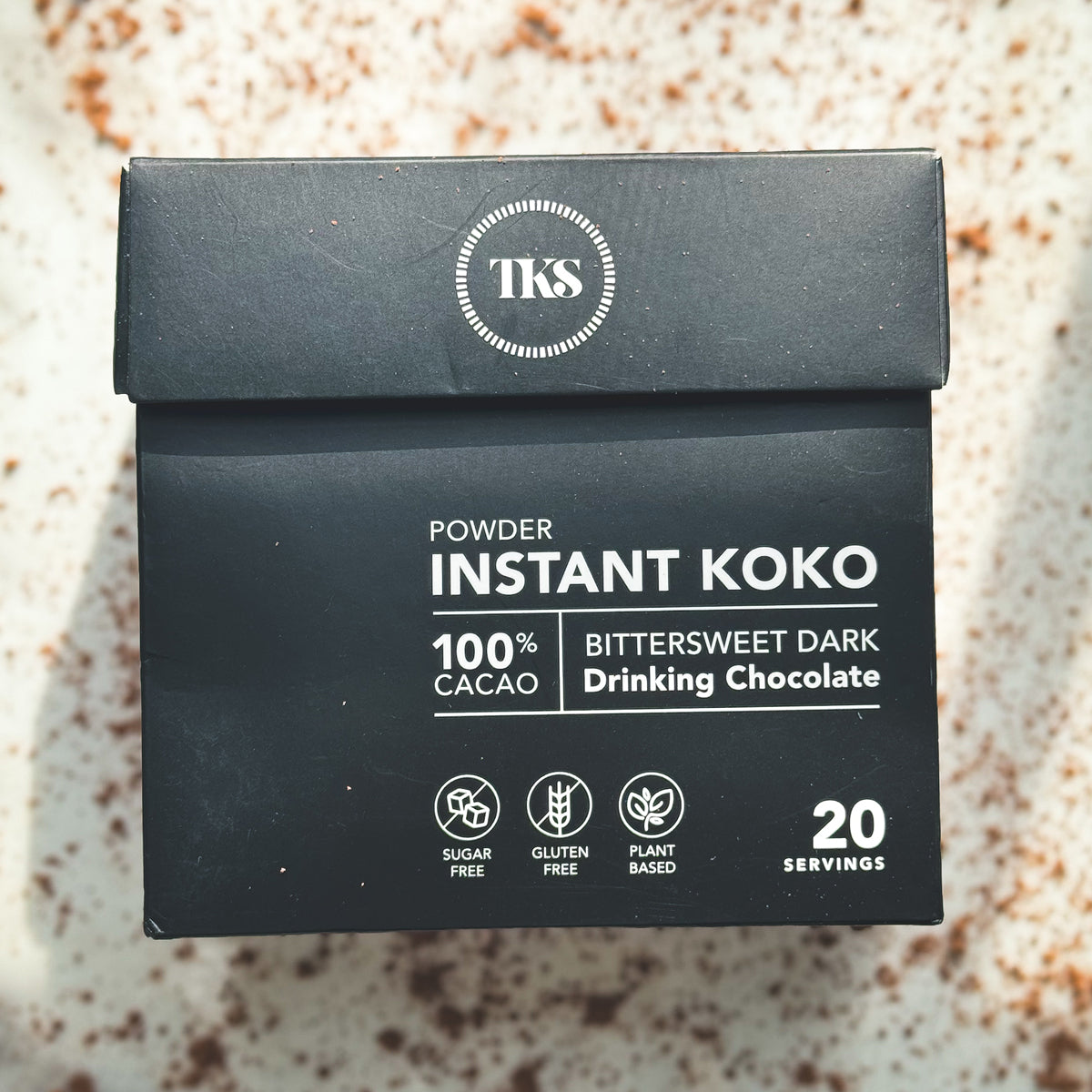 A cup of Instant Koko Samoa drinking chocolate by THE KOKO SAMOA, showcasing rich, creamy cocoa in a warm beverage setting.