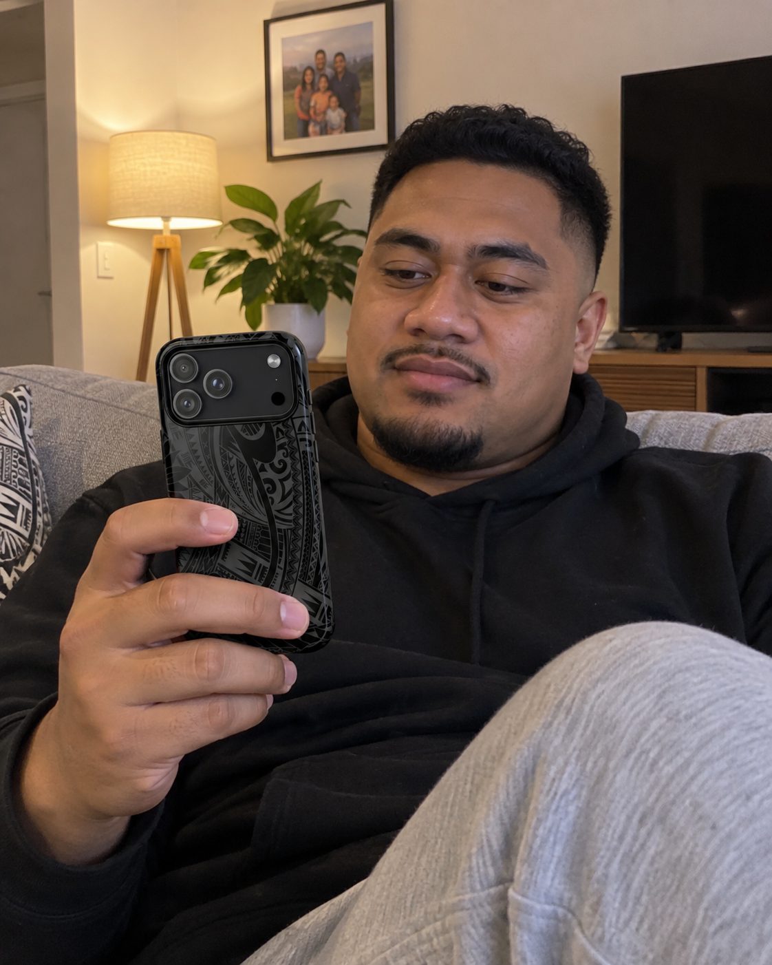 Tough Phone Case in the Warrior print, held while sitting at a kitchen table at home.